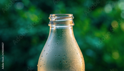 Condensation Covered Bottle in Fresh Outdoor Garden Light.