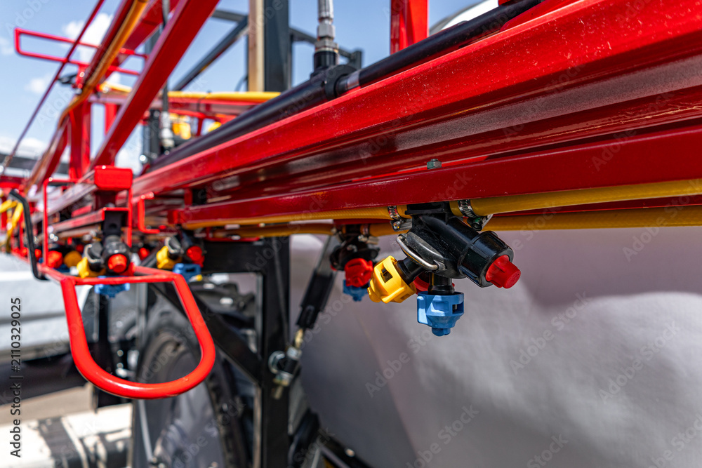 Naklejka premium Agricultural field sprayer nozzle body on boom for pesticide application. Modern crop protection machinery engineering component and farming transport equipment closeup details for cultivation.