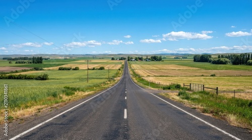 Straight road through green countryside landscape.