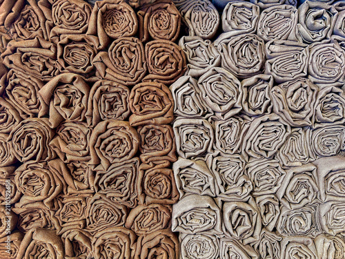 Принти на полотні Neatly rolled fabrics arranged in neutral earth-tone shades, featuring gray and, brown colors
