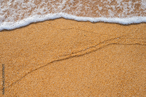 A trace left on the golden beach sand by the gentle incoming ocean tide.