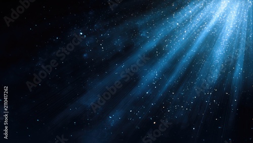 Dramatic view of ethereal blue light rays piercing a dark background with scattered sparkling particles, creating a cosmic effect