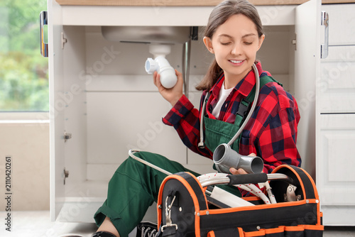 Young female plumber instal...