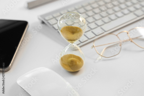 Hourglass with eyeglasses a...