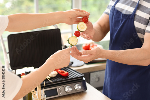 Young couple cooking tasty ...