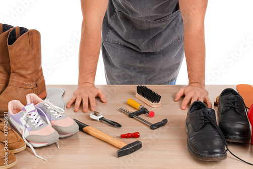 Male shoemaker with tools a...