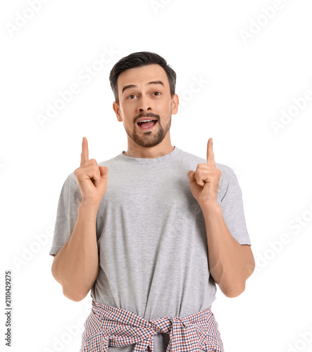 Handsome man pointing at something on white background