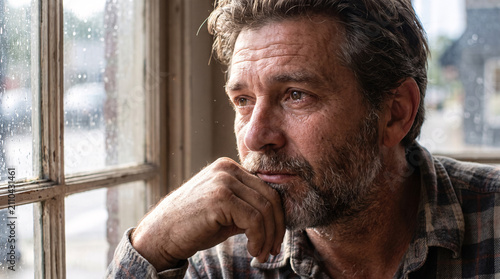 Mature Man Lost in Thought by the Window
