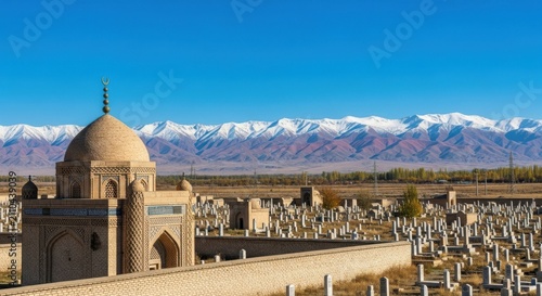 Old cemetery with a mosque building and snow covered mountains in the background