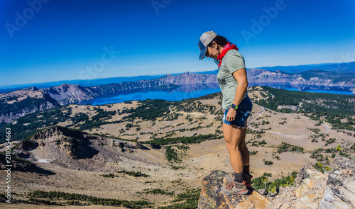 Fotografía Hiker stands atop volcanic peak, gazing at Crater Lake