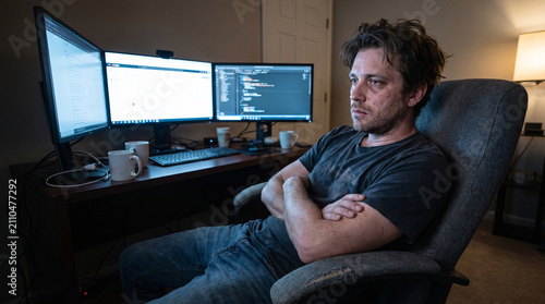 Slouched Man Leaning Back in Chair Facing Computer
