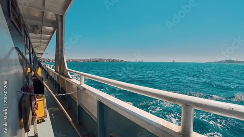Sailing on a ferry over blue water near a coastal city