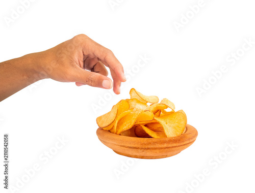 hand gesture reaching for potato chips on a wooden bowl