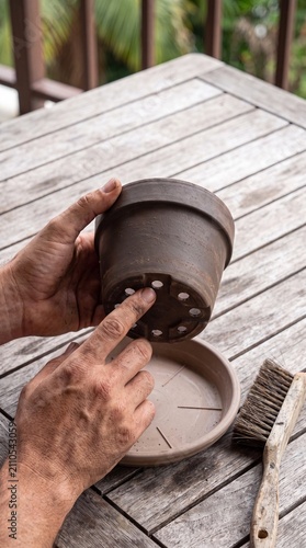 Checking drainage holes of clay flower pot