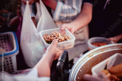 Volunteers donating food to people in a society in need of food , Volunteers Share Food to the Poor