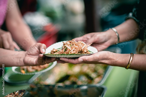 Volunteers donating food to people in a society in need of food , Volunteers Share Food to the Poor