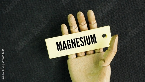 Paper with word Magnesium is a silver-white chemical element with the symbol Mg and atomic number 12, and an essential mineral for human health