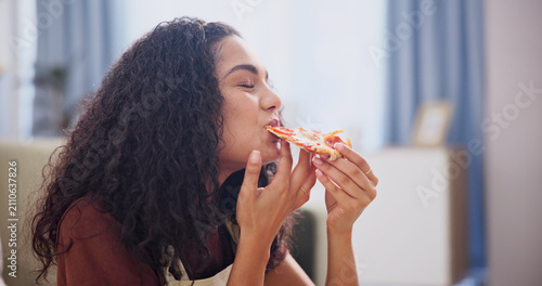 фотографія Eating, relax and woman with pizza in home for dinner, fast food or supper in living room on holiday