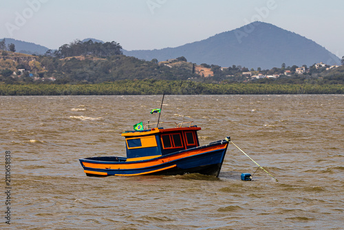 Fotografía Traditional Brazilian wooden fishing boat anchored on choppy sea water