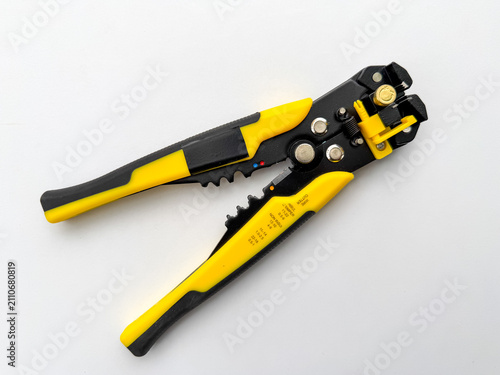 Foto Yellow and black automatic wire stripping tool lying diagonally on white background