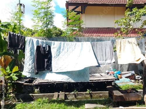 Laundry Hanging on Clothesline Under Bright Sun in Residential Backyard – Everyday Household Chores and Sustainable Air Drying