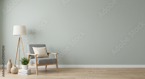 Foto Minimalist living room interior featuring gray armchair beside tall tripod lamp