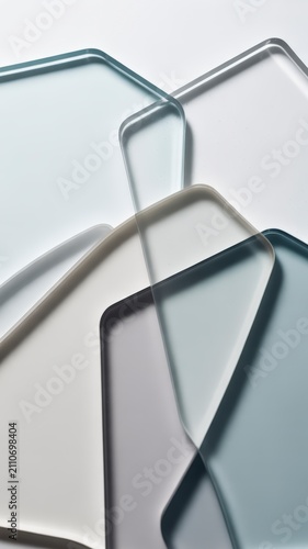 Overlapping rounded frosted and clear glass elements create a modern abstract pattern on a clean surface