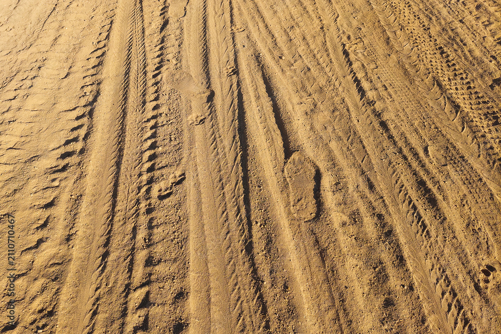Fototapeta premium Texture of Red Soil with Vehicle Tracks