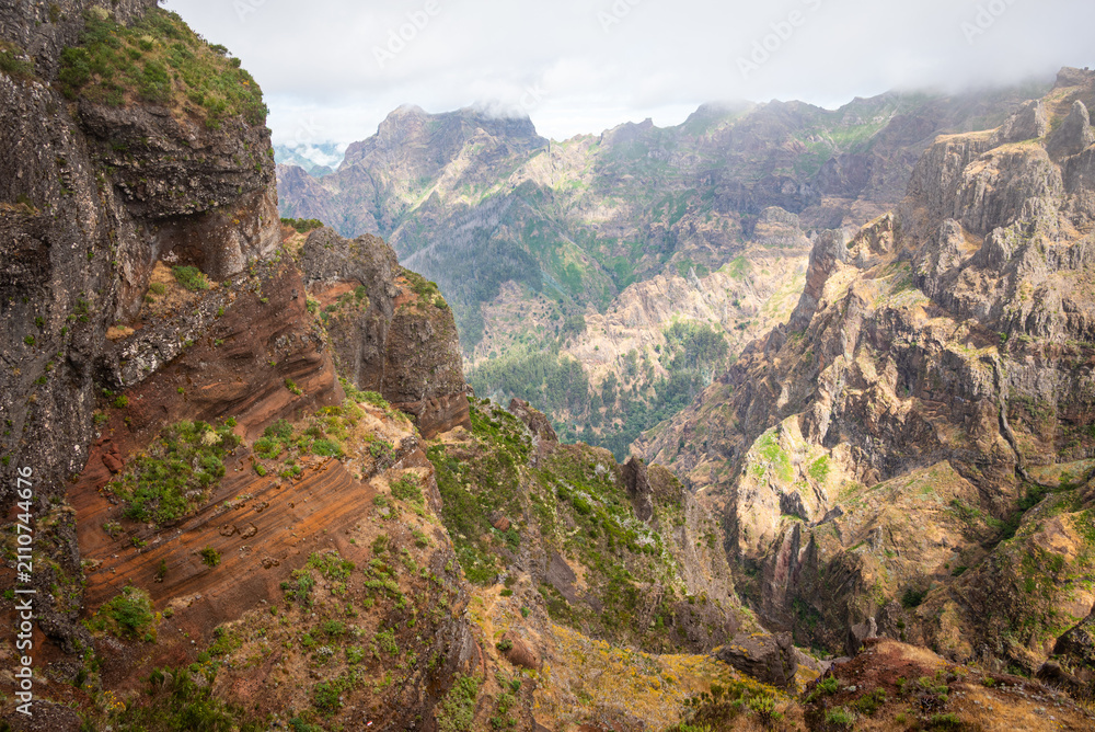 Fototapeta premium Panoramic view of deep valleys and volcanic ridges from the Pico do Areeiro trail, Madeira