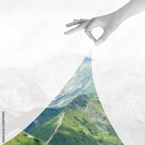 Abstract collage illustration of human hand revealing a lush green mountain peak from a muted landscape background. Grunge, motion, noise and blur effect applied