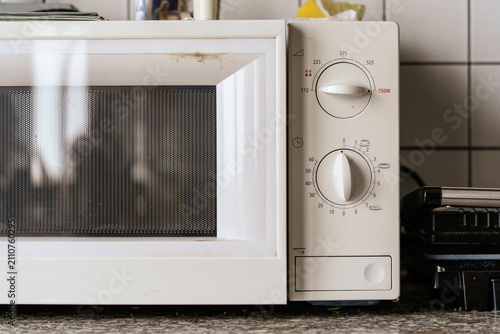 Old microwave oven with dials in kitchen setting