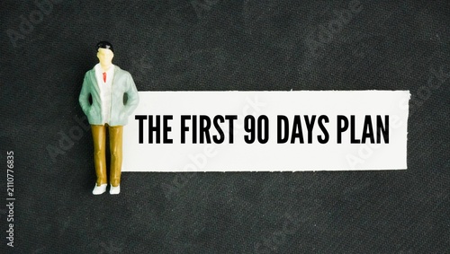 Miniature people and paper with the words the first 90 days plan. strategic roadmap that breaks a new employee's first three months into three distinct phases of learning, contributing, and owning.