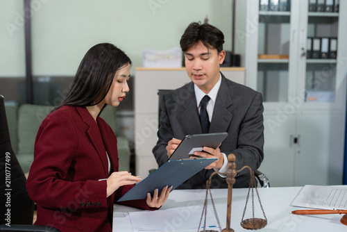 legal counsel reviewing paperwork at a desk in an office, working with a tablet on law and justice matters. Professional attorney in a corporate legal.