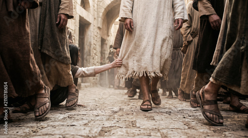 The bleeding woman reaching through a crowded street to secretly touch the hem of Jesus' garment for healing
