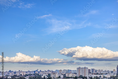 Sky view over a city with buildings and clouds during the day.