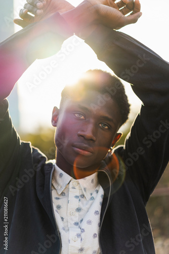 Young man raising arms with crossed wrists