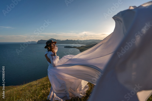 Bild auf Leinwand Woman dress mountain, woman wearing elegant white dress standing on a grassy hil