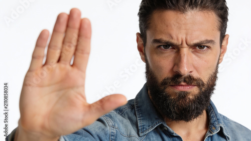 Serious man showing stop gesture with hand signaling refusal, warning or prohibition