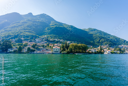 Photography Scenic view of Como Lake with lush green mountains and charming lakeside houses