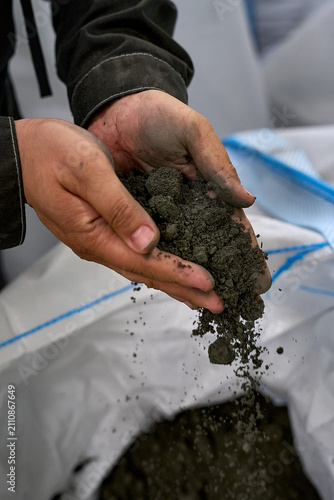 Construction Worker Examining Concrete Mix