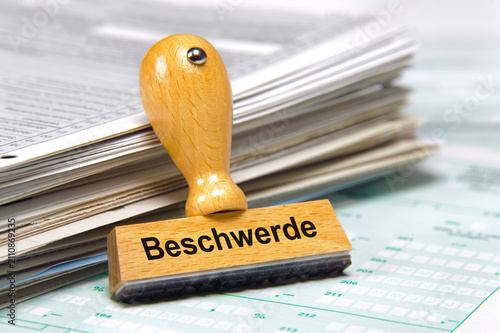 Cuadro en lienzo An einem Stapel mit Papier lehnt ein Holzstempel mit dem Aufdruck: Beschwerde