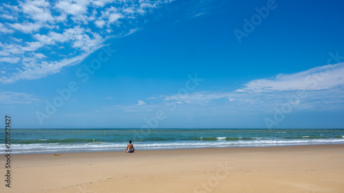Femme assise en position de yoga face à l'océan atlantique sur la plage de la pointe Espagnole dans le département de Charente Maritime