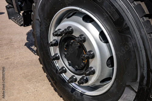 Obraz na plátne Heavy truck wheel steel rim with black lug nuts and hub cap