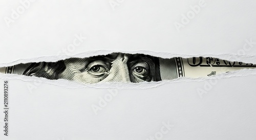 Benjamin Franklin Eyes on 100 Dollar Bill Peeking Through Torn Paper