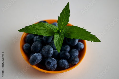 Blueberries with Mint Leaves in Orange Bowl, Top View