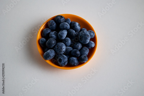 Fresh Blueberries in Orange Bowl on White Background