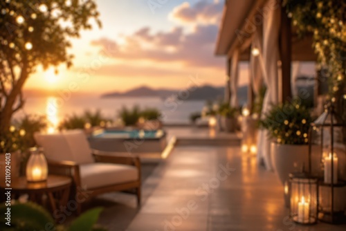 Luxury outdoor terrace patio sunset ocean view lounge furniture candles evening ambiance resort vacation travel lifestyle background blurred