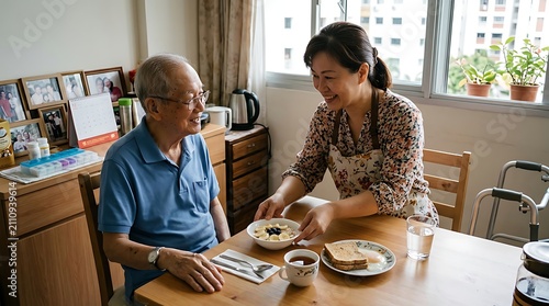 Asian woman serving elderly man breakfast.