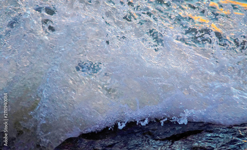 Close up shot splashing sea wave with twilight color light reflected on surface