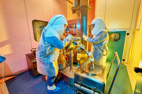 Cleanroom operators processing pharmaceutical products in controlled environment